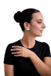 Elegant woman wearing silver statement earrings and minimalist silver rings in a modern jewelry fashion style