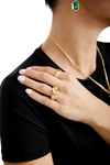Close up of a woman's hand adorned with elegant gold rings, featuring intricate designs, paired with a gold necklace and an emerald pendant, luxury jewelry fashion.