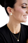 Close-up of Etoile Stud earrings, featuring a gold and white combination, adding timeless elegance to any outfit.