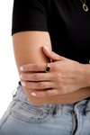 Gold Estelle Ring featuring a black stone, worn gracefully on a woman's hand, paired with white nails and casual chic jeans.