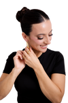 Woman adjusting her Seraphine Hoops, beautifully designed gold earrings that complement her radiant smile and sleek hairstyle.
